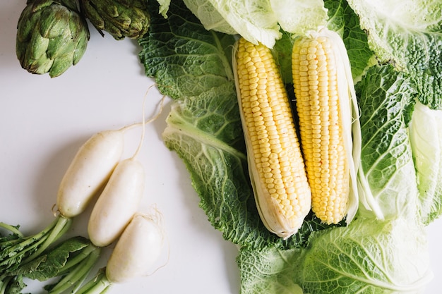 Free photo corn on cabbage leaves near radish