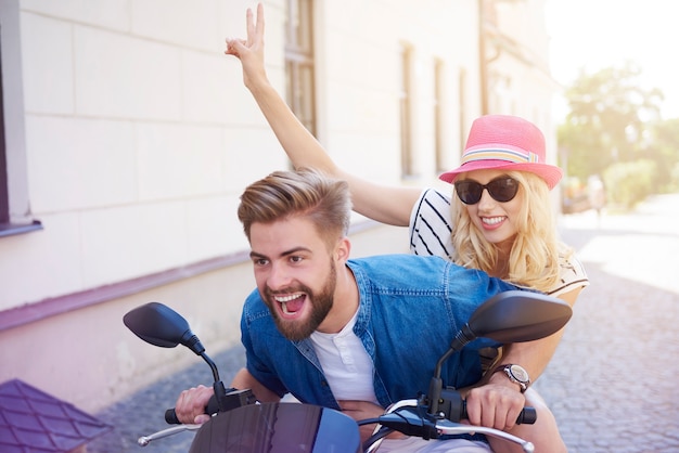 Free photo couple driving a scooter at the city