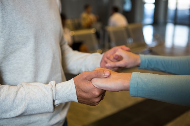 Free Photo couple holding hands in waiting area at airport terminal