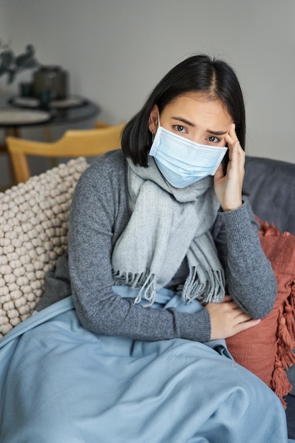 Foto gratuita covid e concetto di salute la giovane donna asiatica in maschera medica si sente malata e non sta bene prendendo l'influenza p