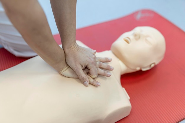 Foto gratuita lezione di rcp con istruttori che parlano e dimostrano le compressioni di pronto soccorso e la procedura di rianimazione manichino rcp