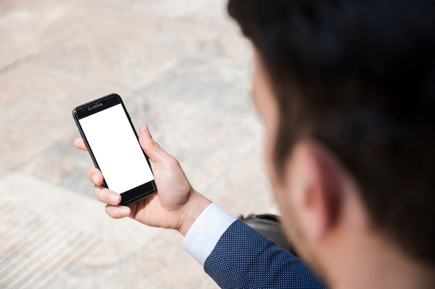 Free photo crop businessman holding smartphone on street