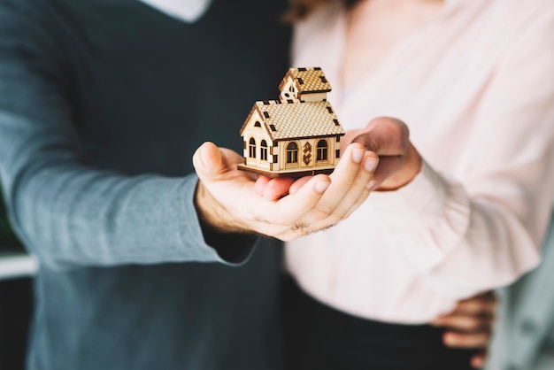 Free photo crop couple holding toy house