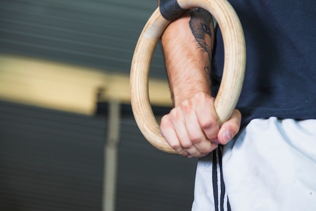 Foto gratuita ritaglia lo sportivo usando anelli da ginnastica