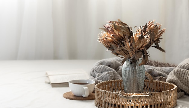 Free photo cup and dried flowers in a vase in the home interior of the living room