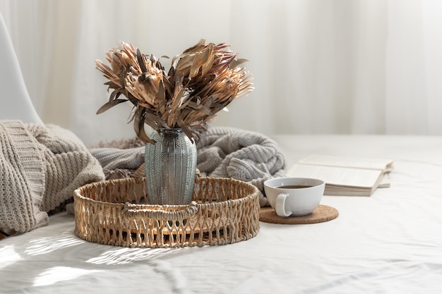 Free photo cup and dried flowers in a vase in the home interior of the living room