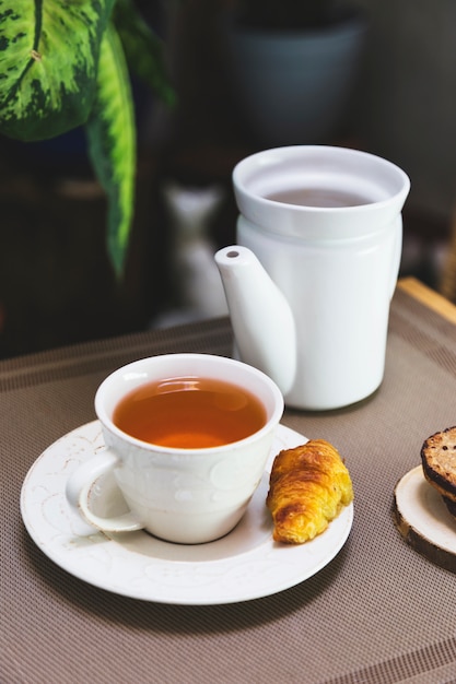 Free Photo cup of tea with teapot and breakfast elements