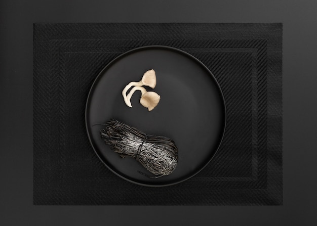 Free photo dark plate with pasta and mushrooms on a dark cloth