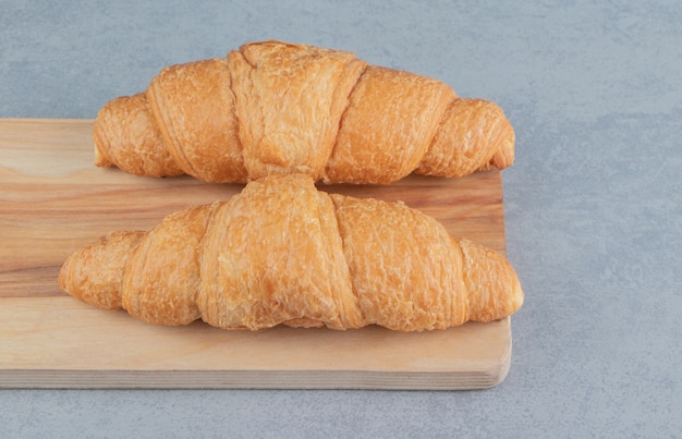 Foto gratuita delizioso croissant sulla tavola, sullo sfondo di marmo. foto di alta qualità