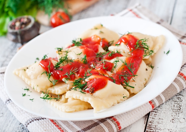 Foto gratuita deliziosi ravioli con salsa di pomodoro e aneto