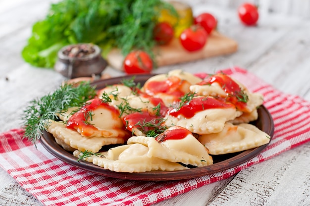 Foto gratuita deliziosi ravioli con salsa di pomodoro e aneto