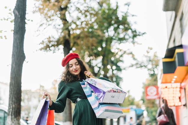 Free photo delighted woman with shopping bags on street