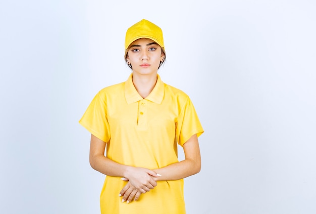 Free Photo delivery woman in yellow uniform standing and looking at camera.