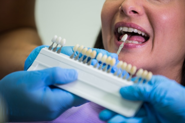 Free photo dentist examining female patient with teeth shades