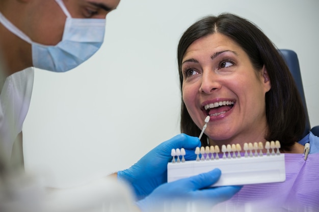 Free photo dentist examining female patient with teeth shades