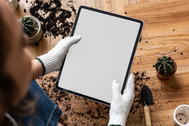 Digital tablet with empty screen on a hand of a gardener