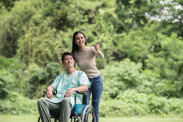 Disabled man in wheelchair and girlfriend in the park