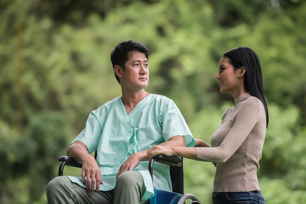 Foto gratuita uomo disabile in sedia a rotelle e fidanzata nel parco