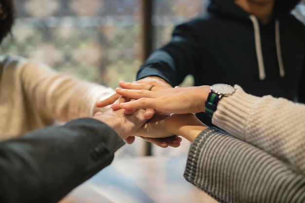 Diverse people stacking hands together