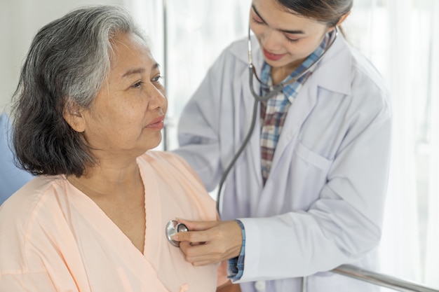 Free photo doctor examining senior elderly  female patient in hospital bed patients - medical and healthcare senior concept