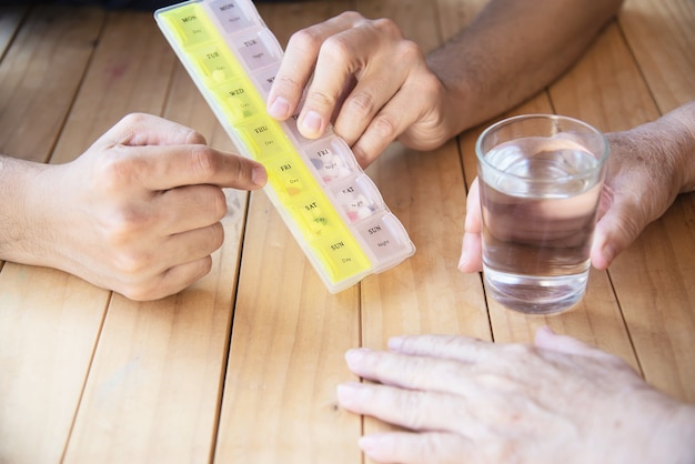 Free Photo doctor is assist patient to eat medicine tablet in pillbox correctly 