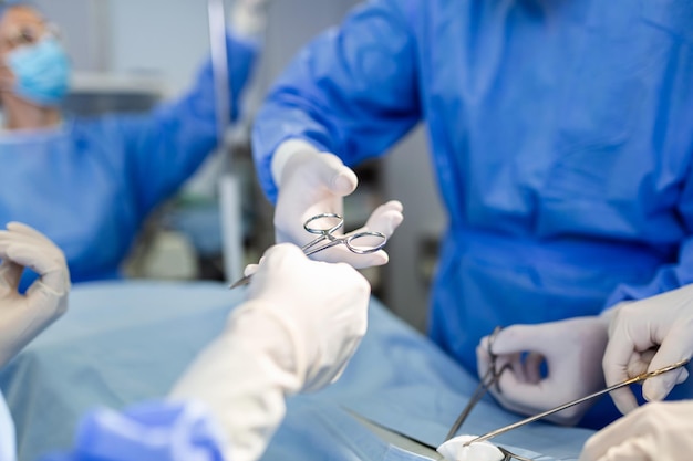 Free Photo doctor and nurse medical team are performing surgical operation at emergency room in hospital assistant hands out scissor and instruments to surgeons during operation