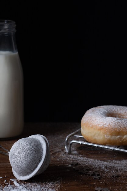 Doughnut with powdered sugar glazing and milk bottle