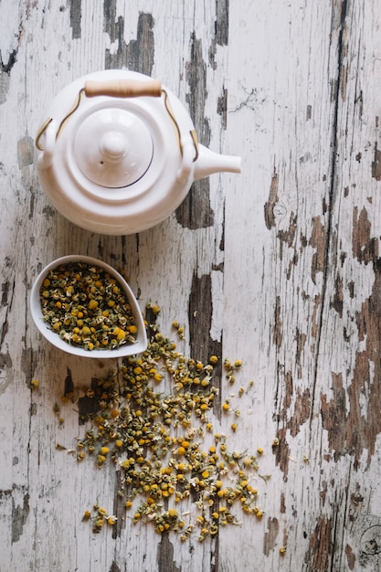 Free photo dried chamomiles and white teapot