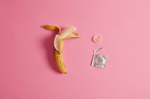 Free photo effective preventing pregnancy product for your safety. open condon package with a banana.