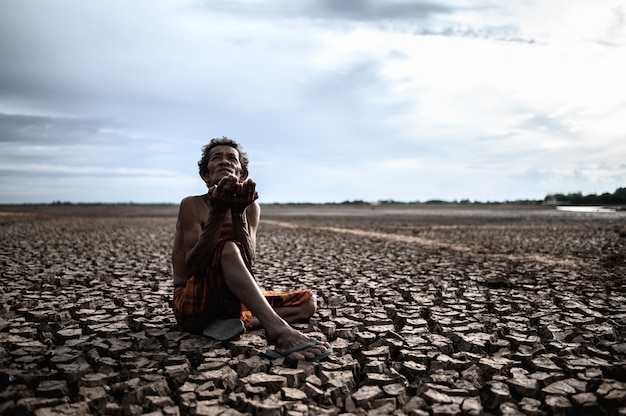 An elderly man was sitting asking for rain in the dry season, global warming