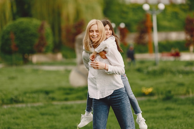 Free photo elegant mother with daughter in a summer forest