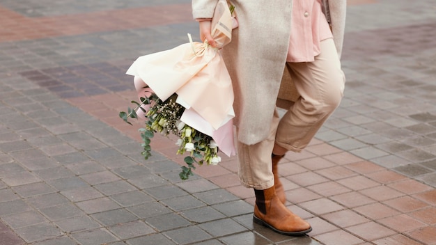 Elegant woman in the city holding bouquet of flowers