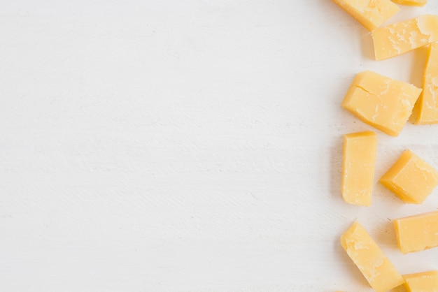 Free photo an elevated view of cheddar cheese slices on white background