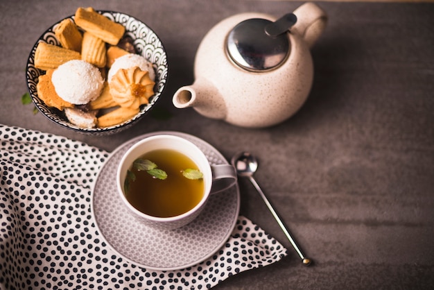 Free photo elevated view of herbal tea; cookies and teapot on table