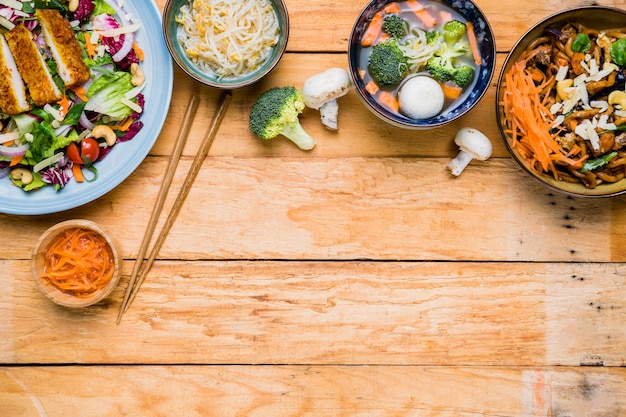 Free Photo an elevated view of traditional thai food with chopsticks on wooden desk