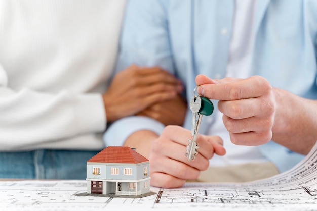 Free photo embraced defocused couple holding the keys to their new house