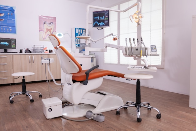 Free photo empty modern teethcare stomatology hospital office with nobody in it equipped with dental intruments ready for orthodontist healthcare treatment. tooth radiography images on display