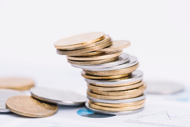 Free photo fallen stack of coins on white background over the graph