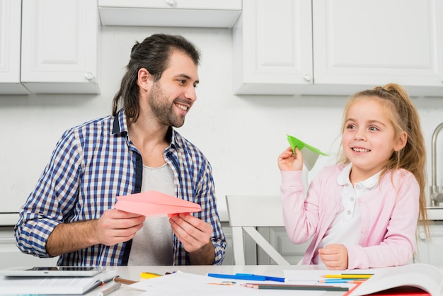 Free photo father and daughter playing with planes