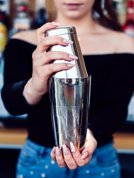 Free photo female bartender preparing drink in shaker