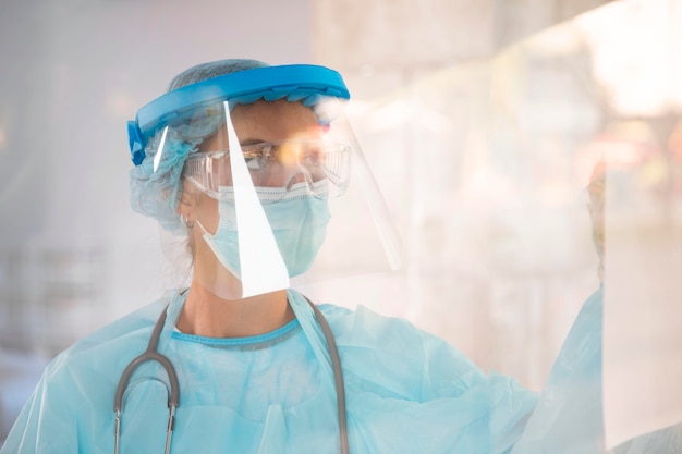 Free photo female doctor in protective wear looking away