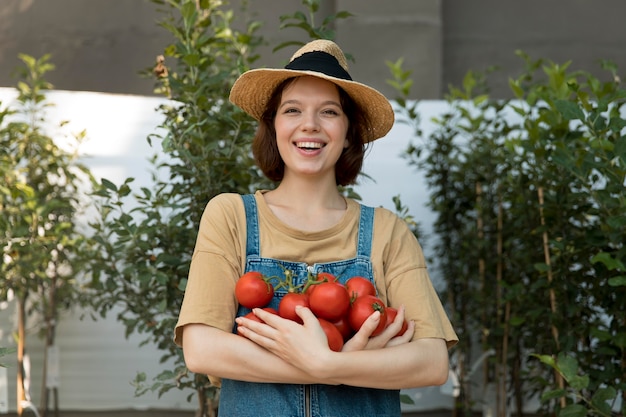 Free photo female farmer holding some tomatoes