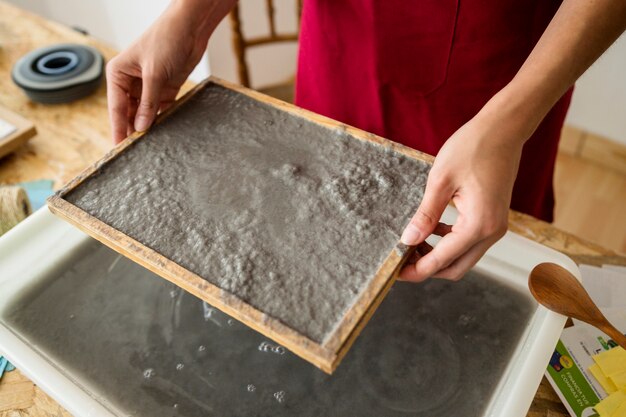 Female's hand holding mold with paper pulp