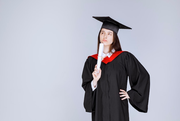 Free photo female student with college diploma posing to camera. high quality photo