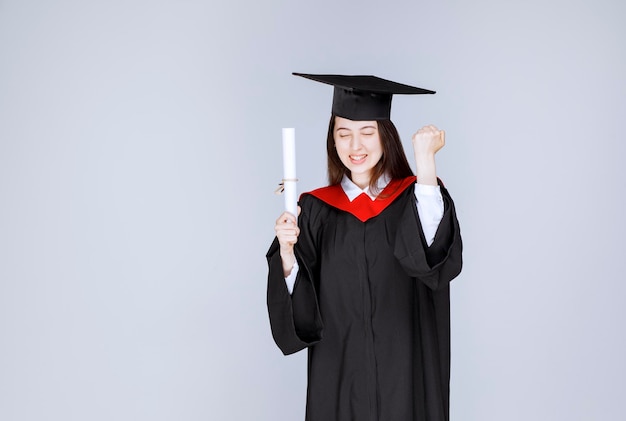 Free photo female student with college diploma posing to camera. high quality photo