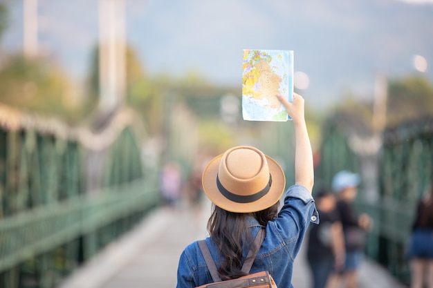 Foto gratuita i turisti femminili a disposizione hanno una mappa di viaggio felice.