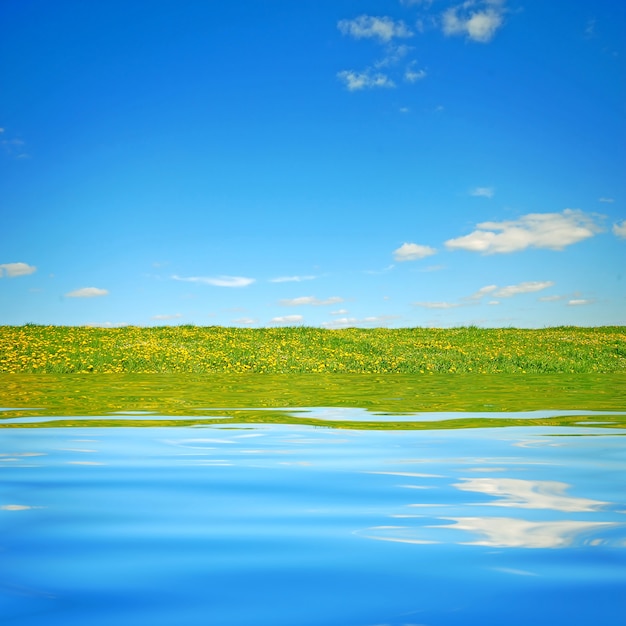 Free photo field seen from a lake