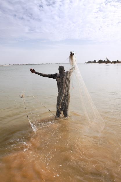 Free photo fisherman with net on the river