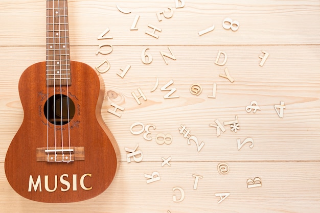 Foto gratuita chitarra acustica piatta con lettere in legno