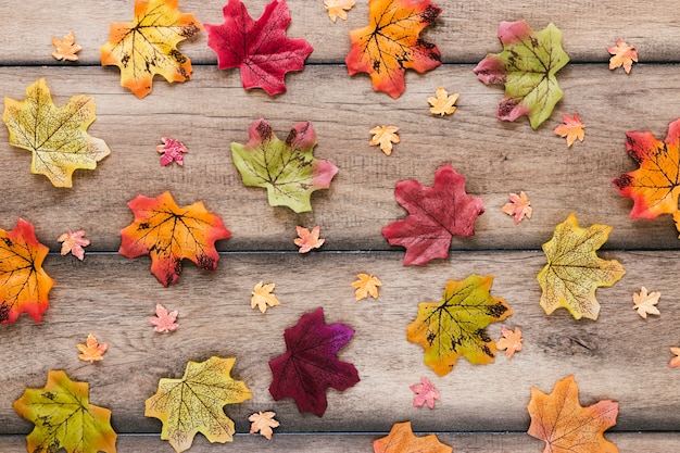 Free photo flat lay autumn leaves on wooden table